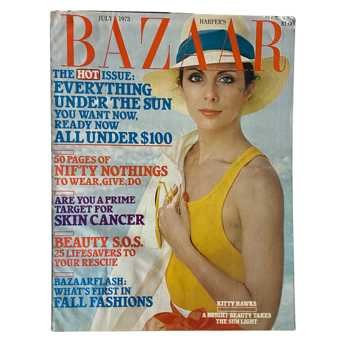Cover of Harper's Bazaar Magazine July 1973 featuring Kitty Hawks in a yellow dress and wide-brimmed hat, highlighting bold fashion trends of the early '70s.