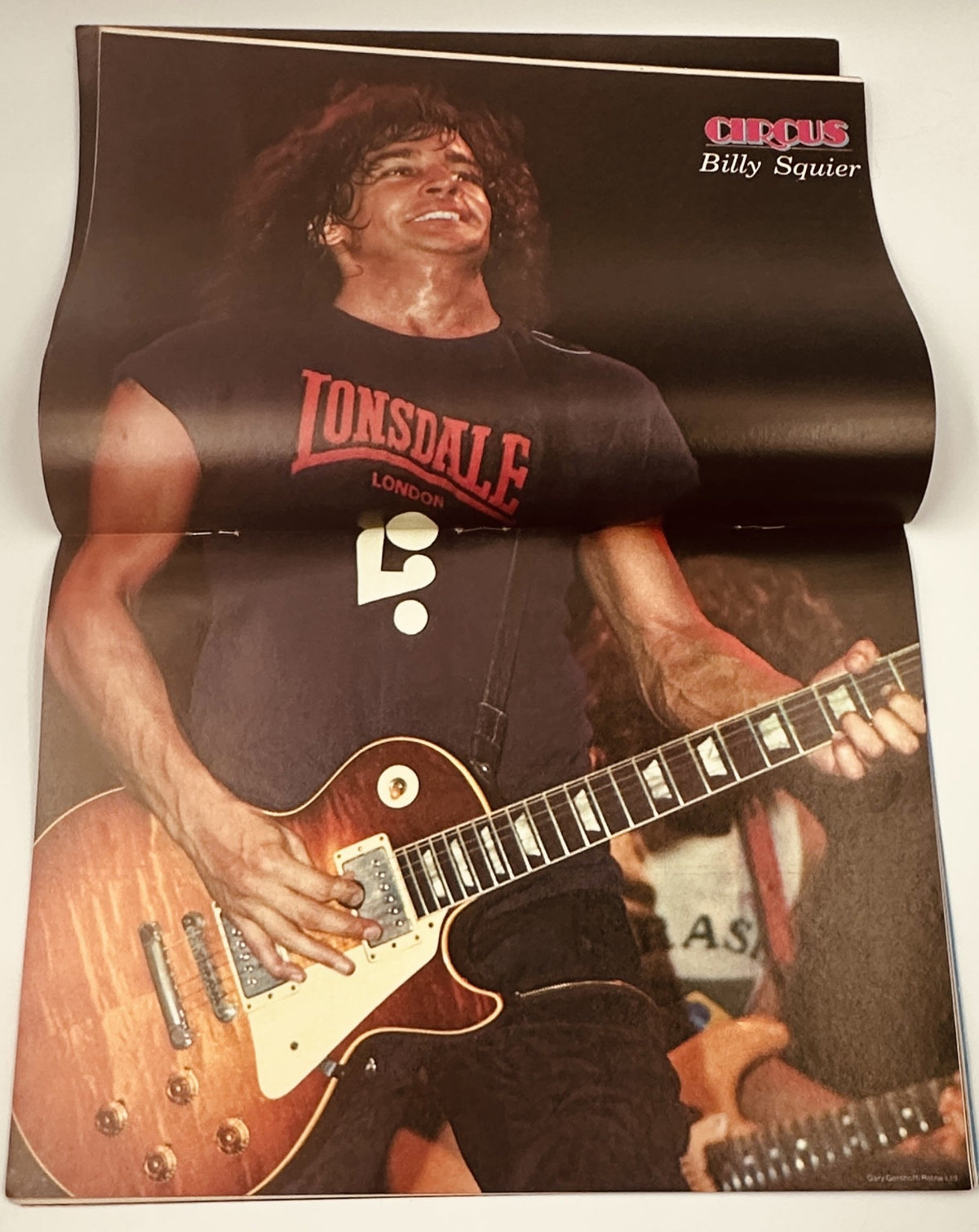 Image of Billy Squier performing on stage, featured in the Circus Magazine May 31, 1982 issue, showcasing his energetic performance style.