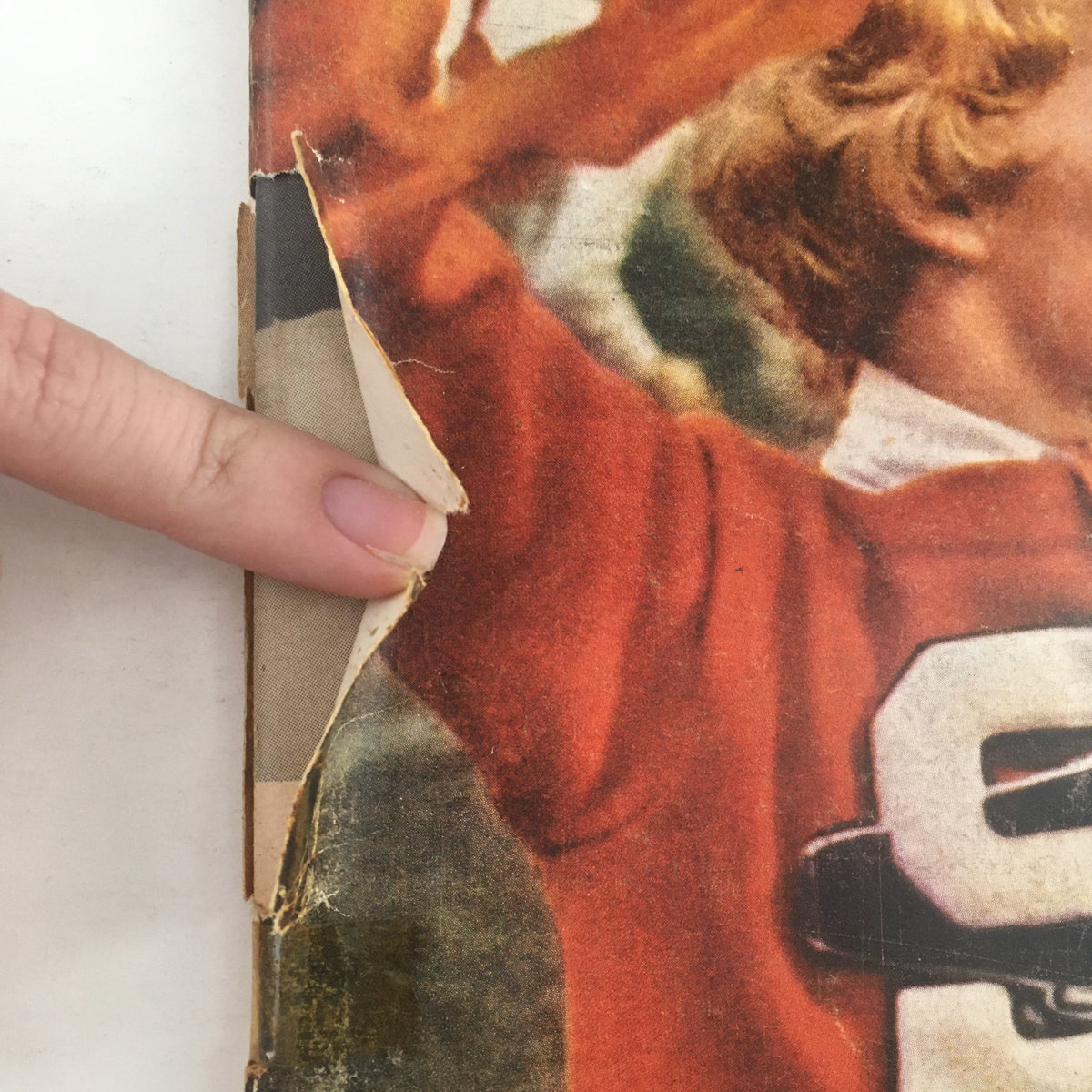 Detailed view of the tears and wear on the cover of Sports Illustrated Magazine September 19 1960, showcasing the vintage condition of this collectible sports publication.