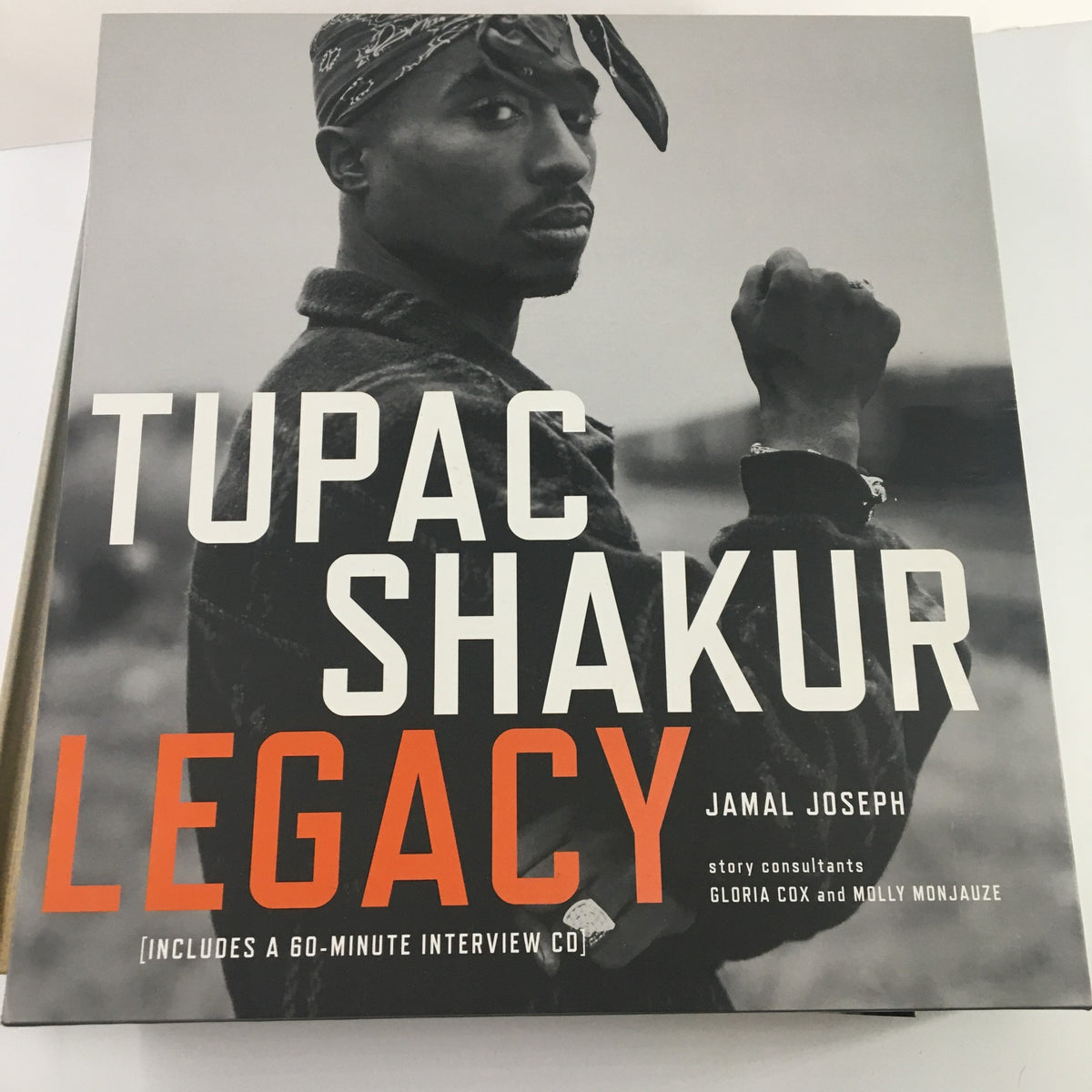 Tupac Shakur Legacy book cover showcasing Tupac with a bandana, emphasizing the title and author's name, Jamal Joseph.