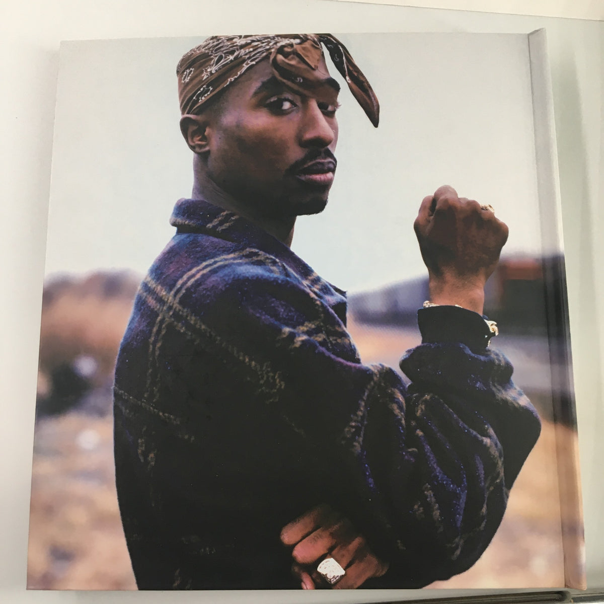 An iconic portrait of Tupac Shakur featured in the Tupac Shakur Legacy book, showcasing his distinctive style and strong expression.