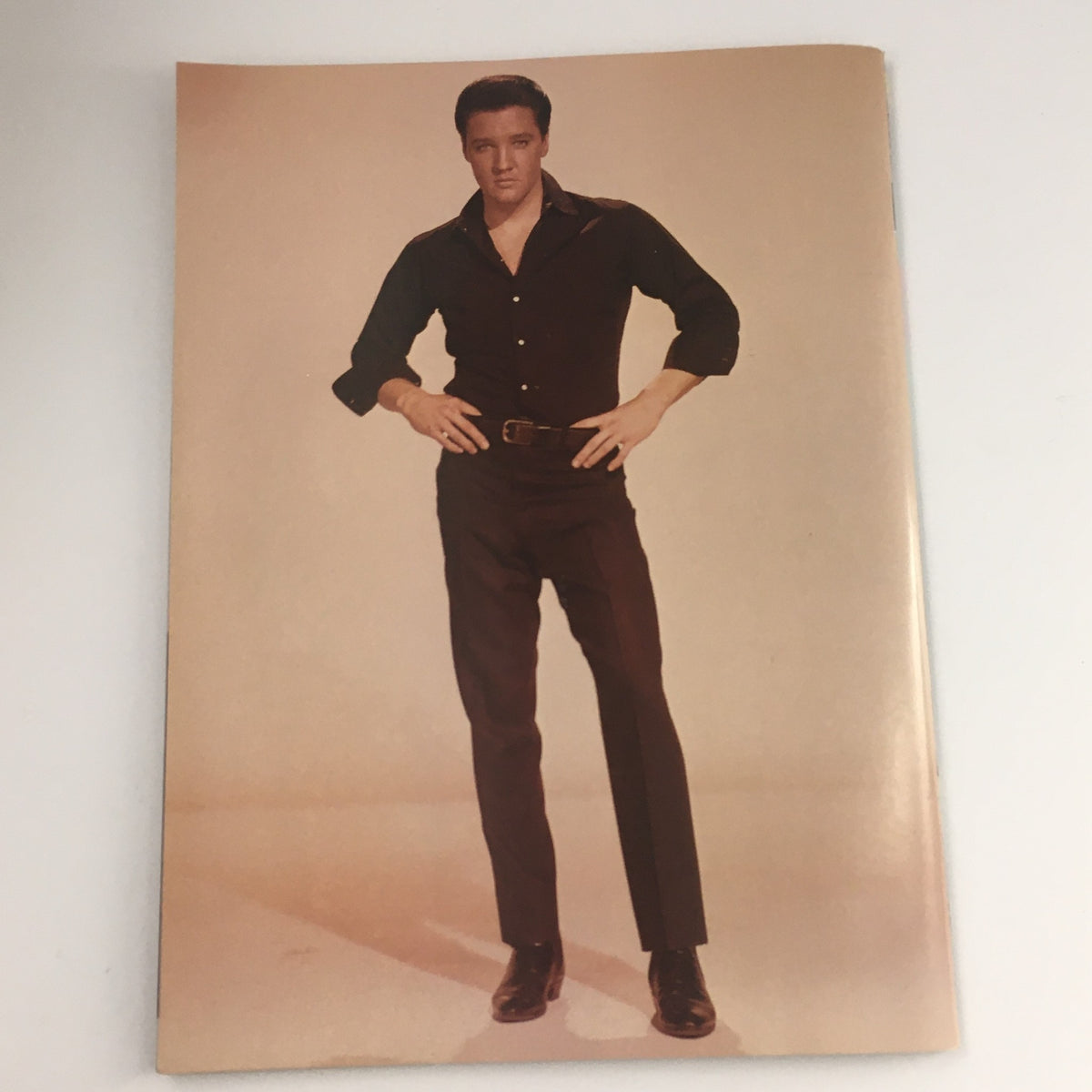 Full-page photo from Movie Screen Yearbook #42 Elvis Presley The Complete History, depicting Elvis Presley in a black shirt and pants, showcasing his iconic look.
