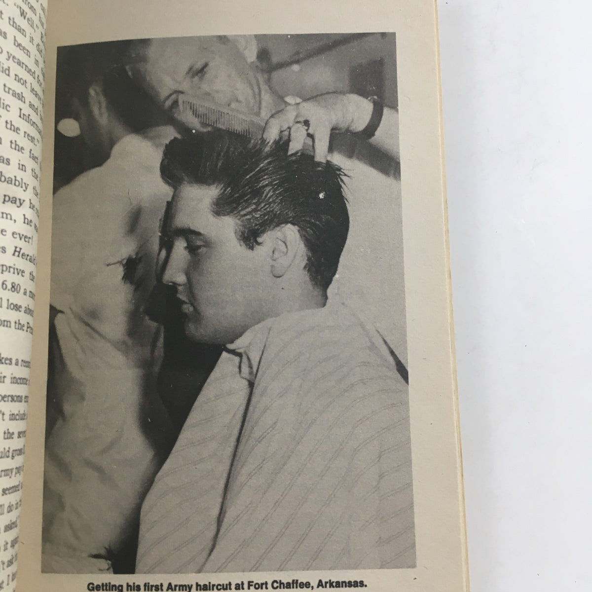 Interior page from 1973 Vintage Book Meet Elvis Presley by Favius Friedman, depicting a black-and-white image of Elvis Presley receiving his first Army haircut at Fort Chaffee, Arkansas.