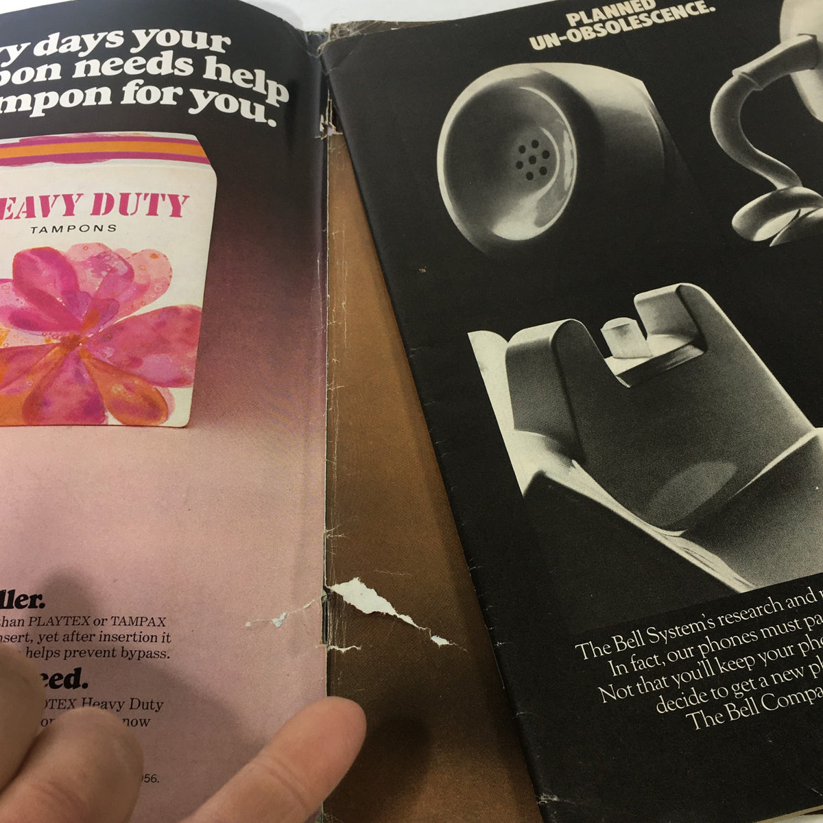 Inside pages of Vintage Ms. Magazine, July 1975, showing advertisements, including a tampon ad and a black-and-white image of a telephone, highlighting varied content within the magazine.