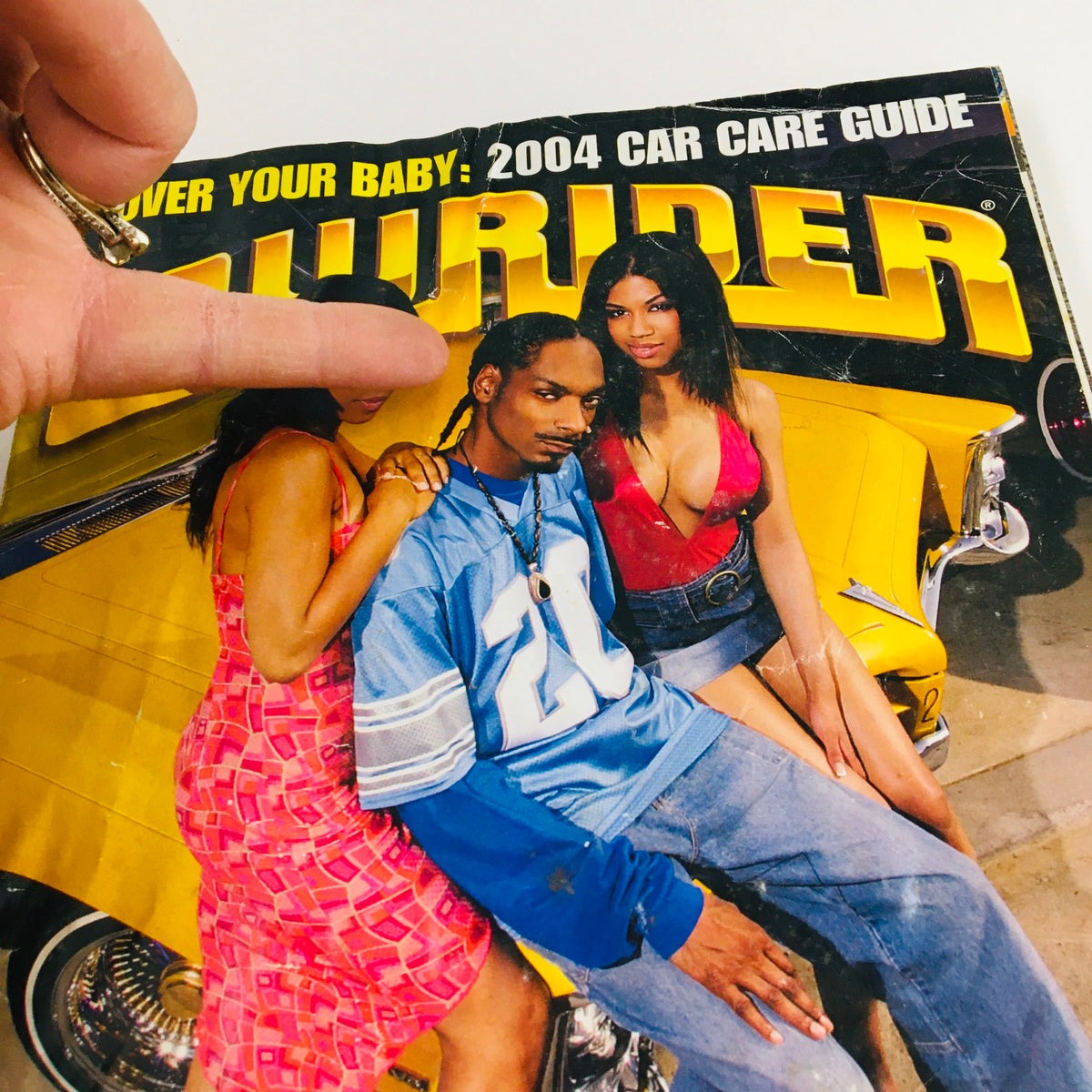 Cover of LowRider Magazine July 2004 titled 'A Day In The Life of Snoop Dogg' featuring Snoop Dogg with two women beside a lowrider car.