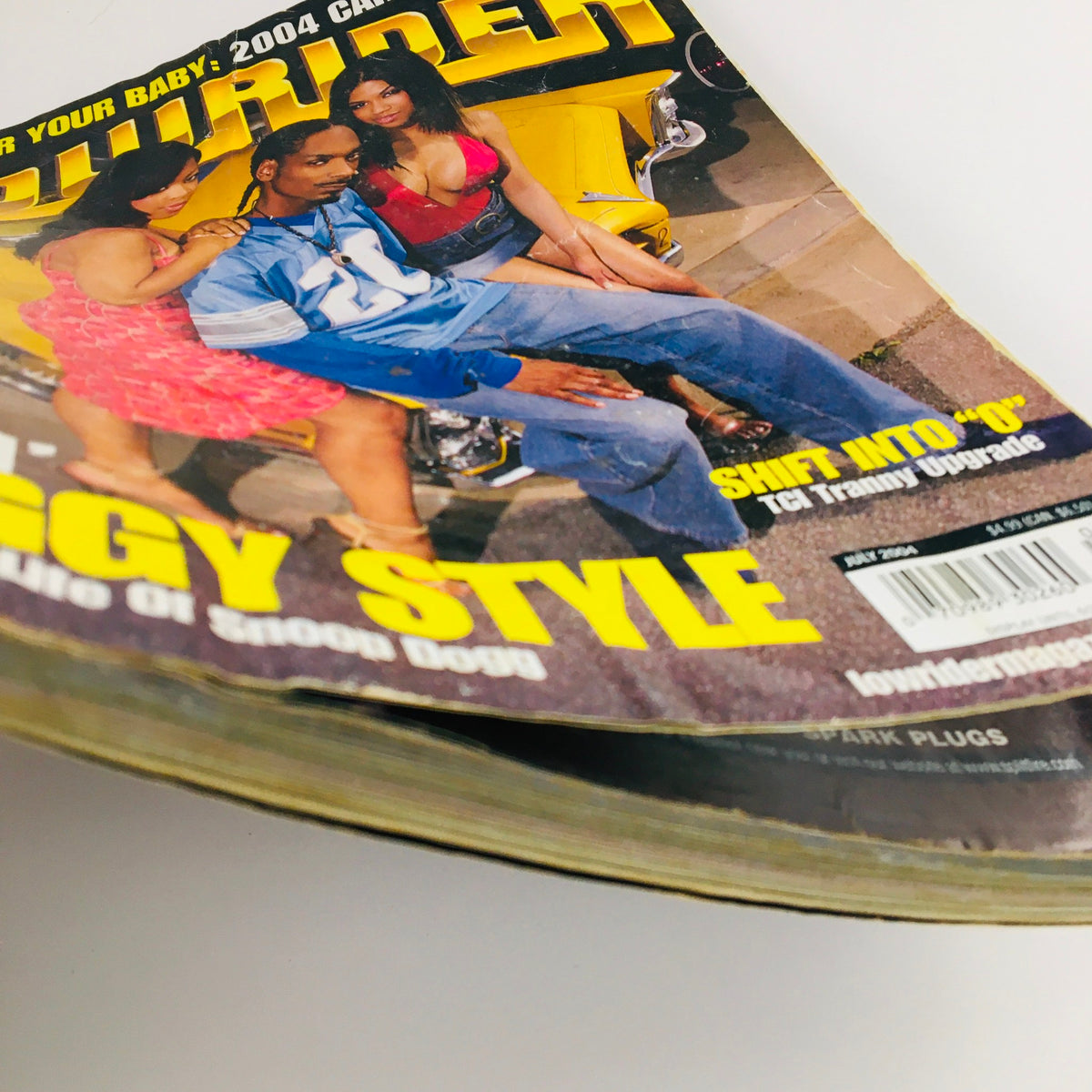 Side view of LowRider Magazine July 2004, showcasing the title 'A Day In The Life of Snoop Dogg' along with images from the car care guide.