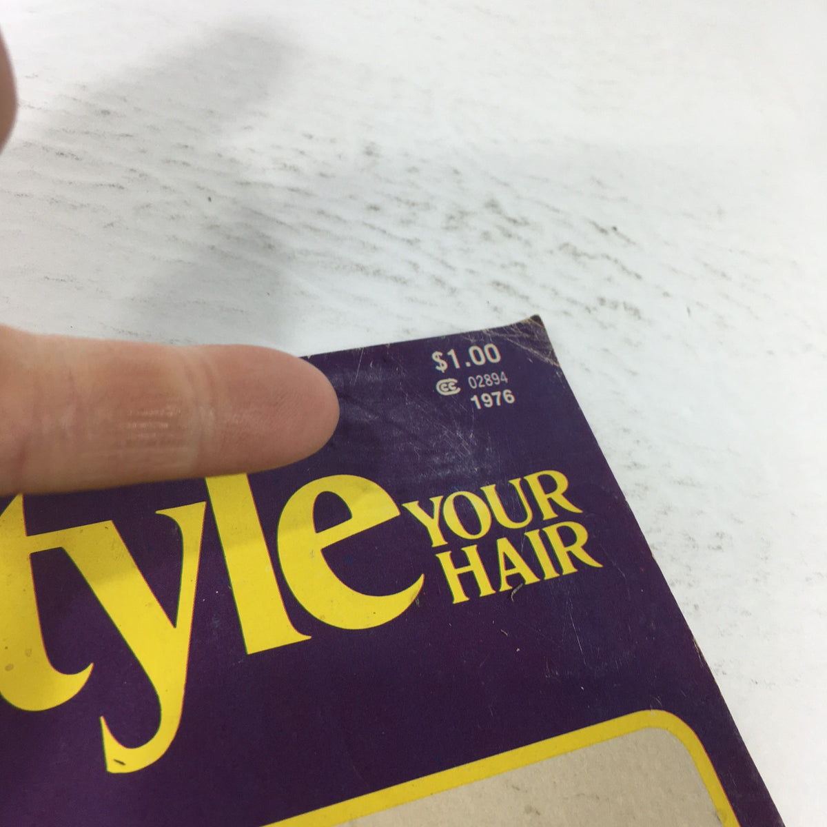 Close-up of the top corner of the VTG Set'N Style Magazine: 1976 displaying the price tag and publication year, emphasizing its vintage status.