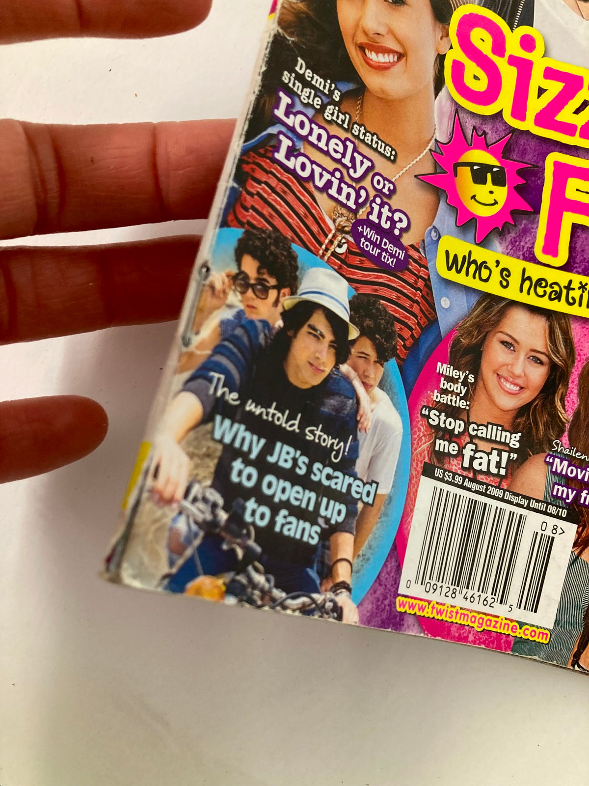 Close-up of Twist Magazine August 2009 showing a feature on Demi Lovato, titled 'Lonely or Lovin' it?' with a tagline about the Jonas Brothers and a candid photo with a bicycle.