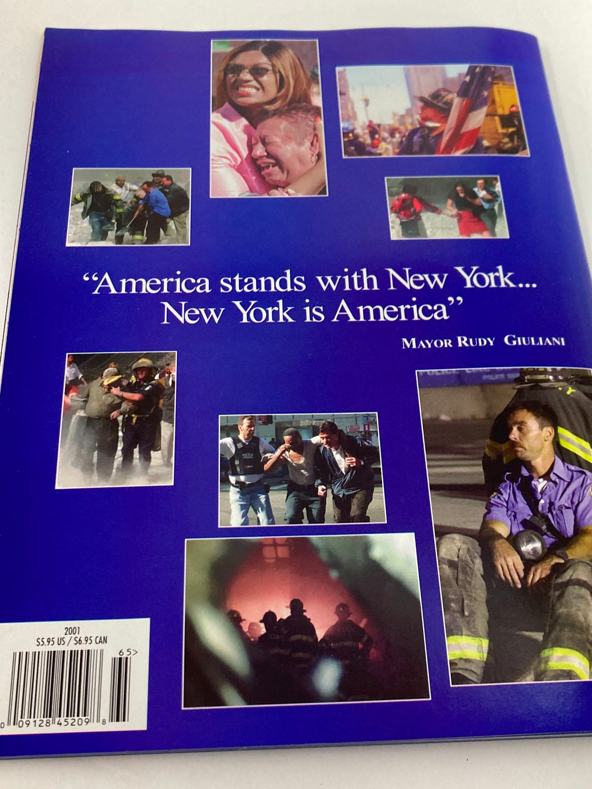 Cover of the magazine 'September 11 2001 Standing Strong: The Spirit of New York', featuring images of rescue efforts and a quote from Mayor Rudy Giuliani, symbolizing solidarity and recovery.