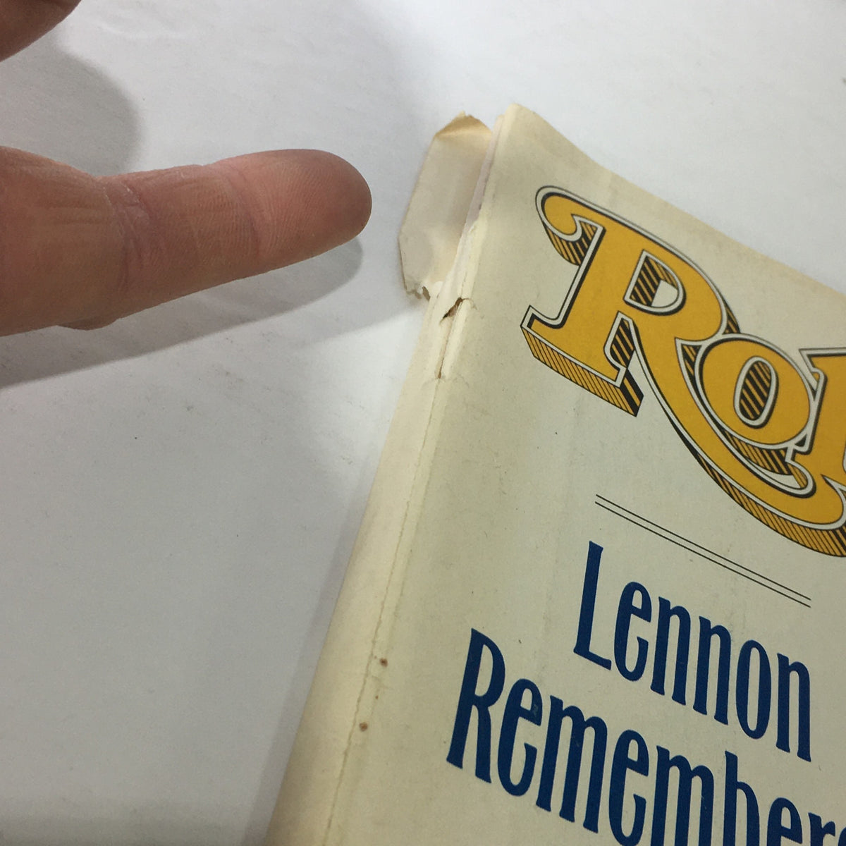 Close-up view of the edge of the vintage Rolling Stone Magazine cover from October 20, 1988, showing wear and the title 'Lennon Remembered'.