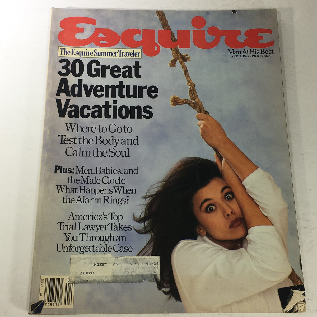 Cover of VTG Esquire Magazine from April 1985 featuring the title 'The Esquire Summer Traveler Vacations' with a focus on '30 Great Adventure Vacations' and a woman holding onto a rope, offering a nostalgic glimpse into 1980s travel culture.