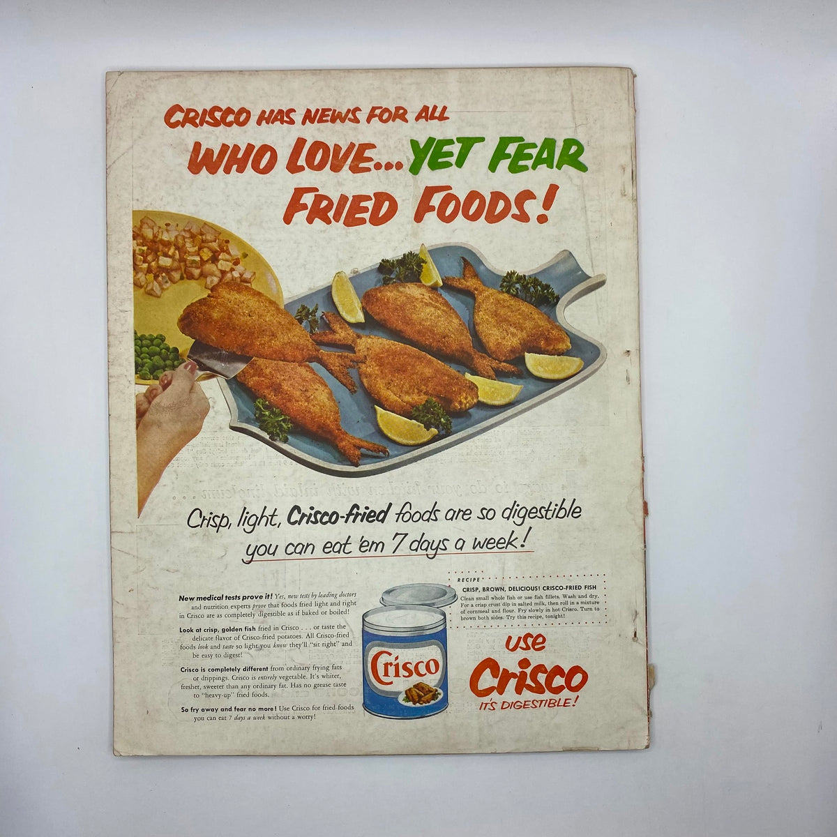 Back cover of the March 1954 edition of McCall's Magazine, featuring an advertisement for Crisco with text discussing the digestibility of fried foods and a recipe for crisp fried fish.