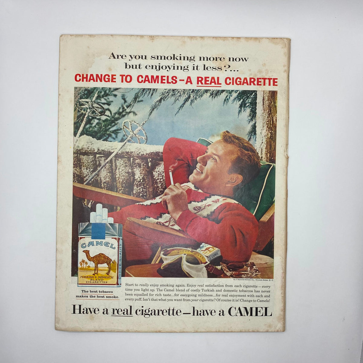 Vintage advertisement from the Saturday Evening Post Magazine December 5, 1959, promoting Camel cigarettes with a relaxed man enjoying a cigarette in a winter setting.