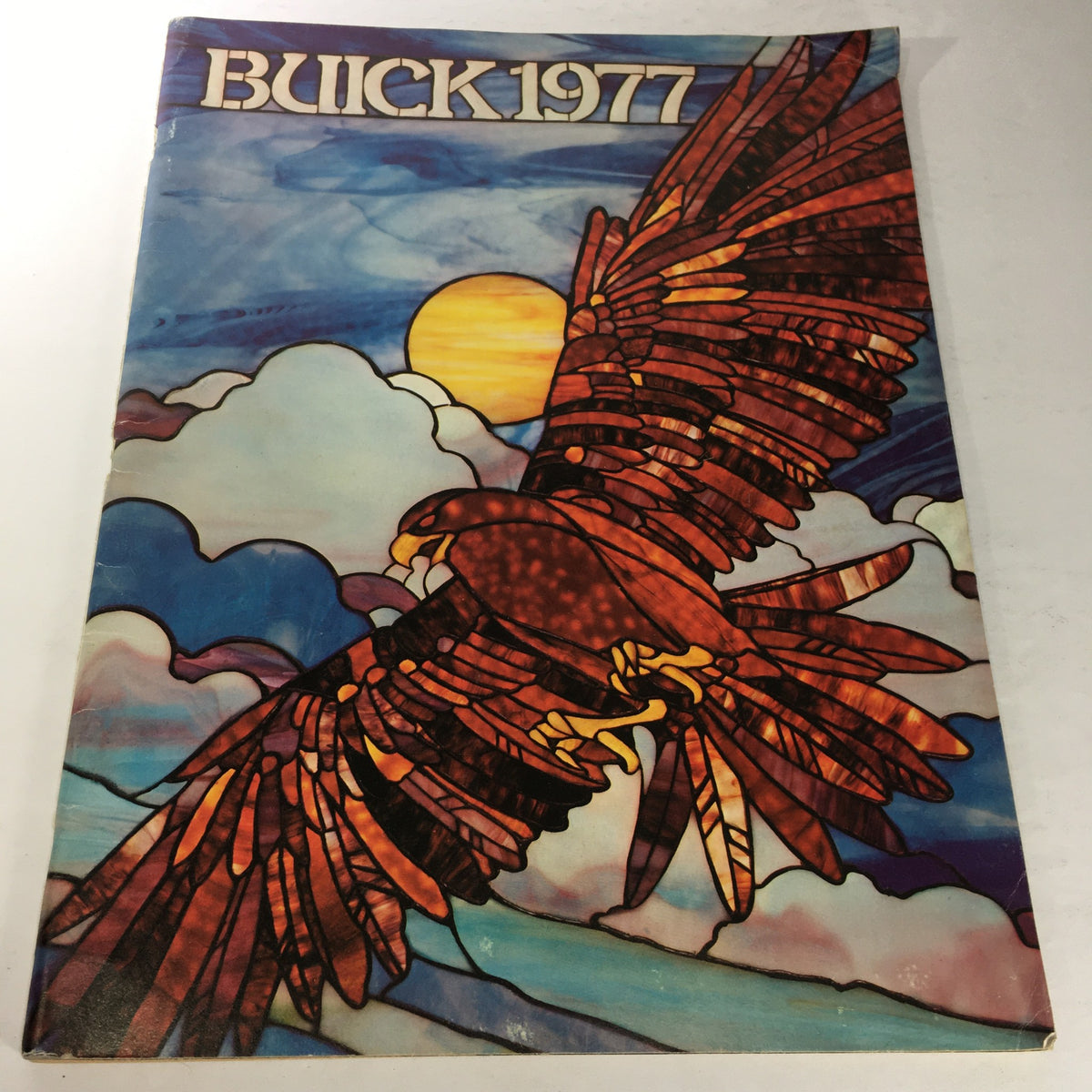 Cover of the 1977 Buick Buyer's Guide featuring an artistic depiction of an eagle soaring against a colorful sky, highlighting the vintage style of the Electra, Riviera, and Skylark models.