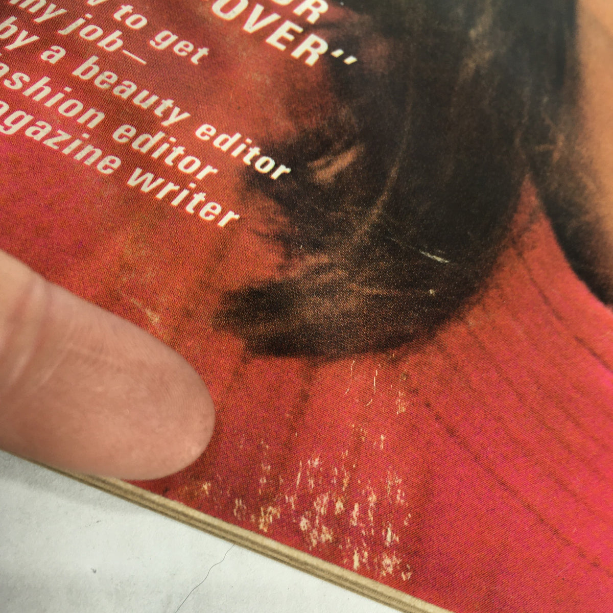 Detail shot of the VTG Glamour Magazine: October 1965 cover, showing text related to beauty tips and magazine content, along with a glimpse of wear and age.