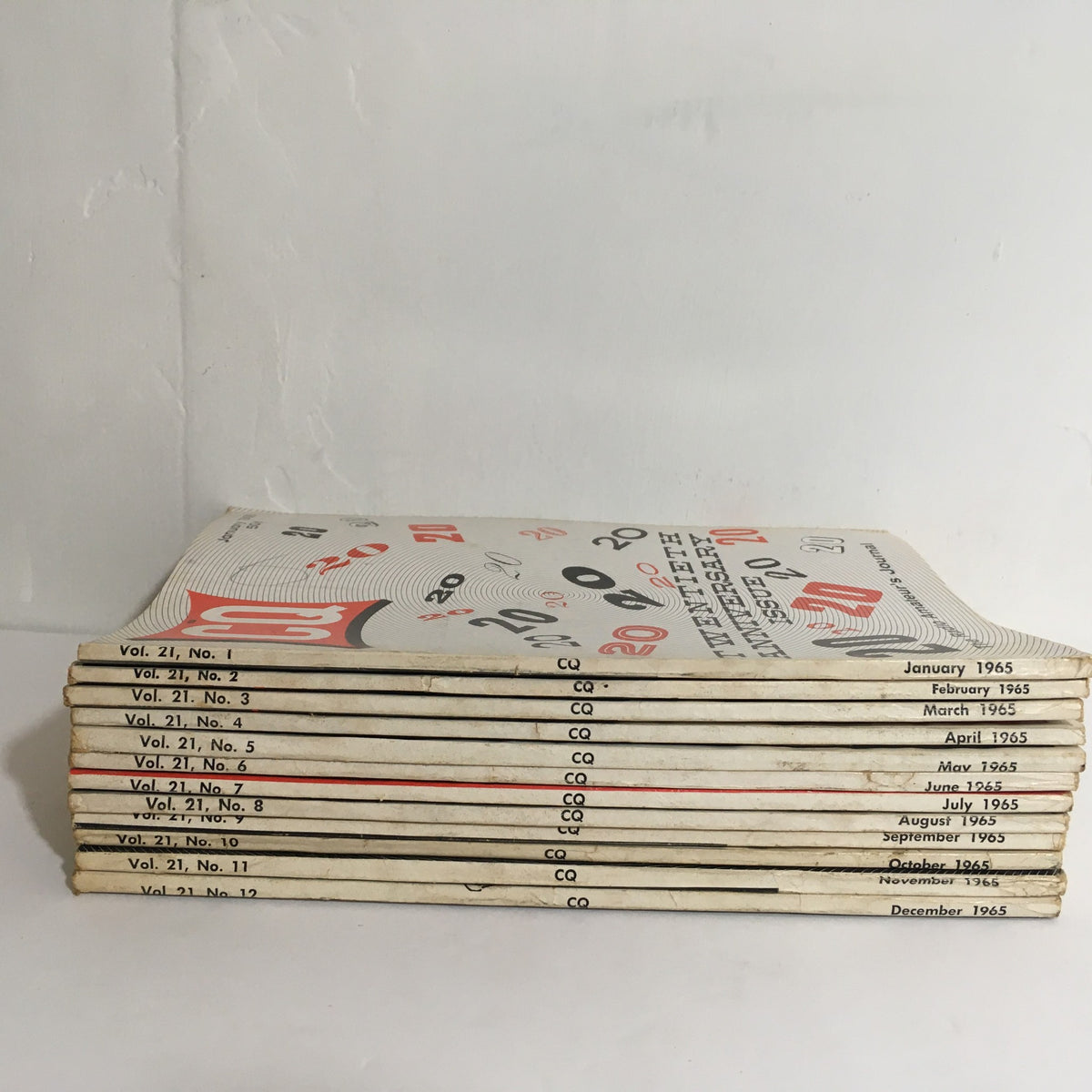 Side view of a stacked collection of 12 issues of CQ The Radio Amateur's Journal from January to December 1965, showcasing the titles and volume numbers.
