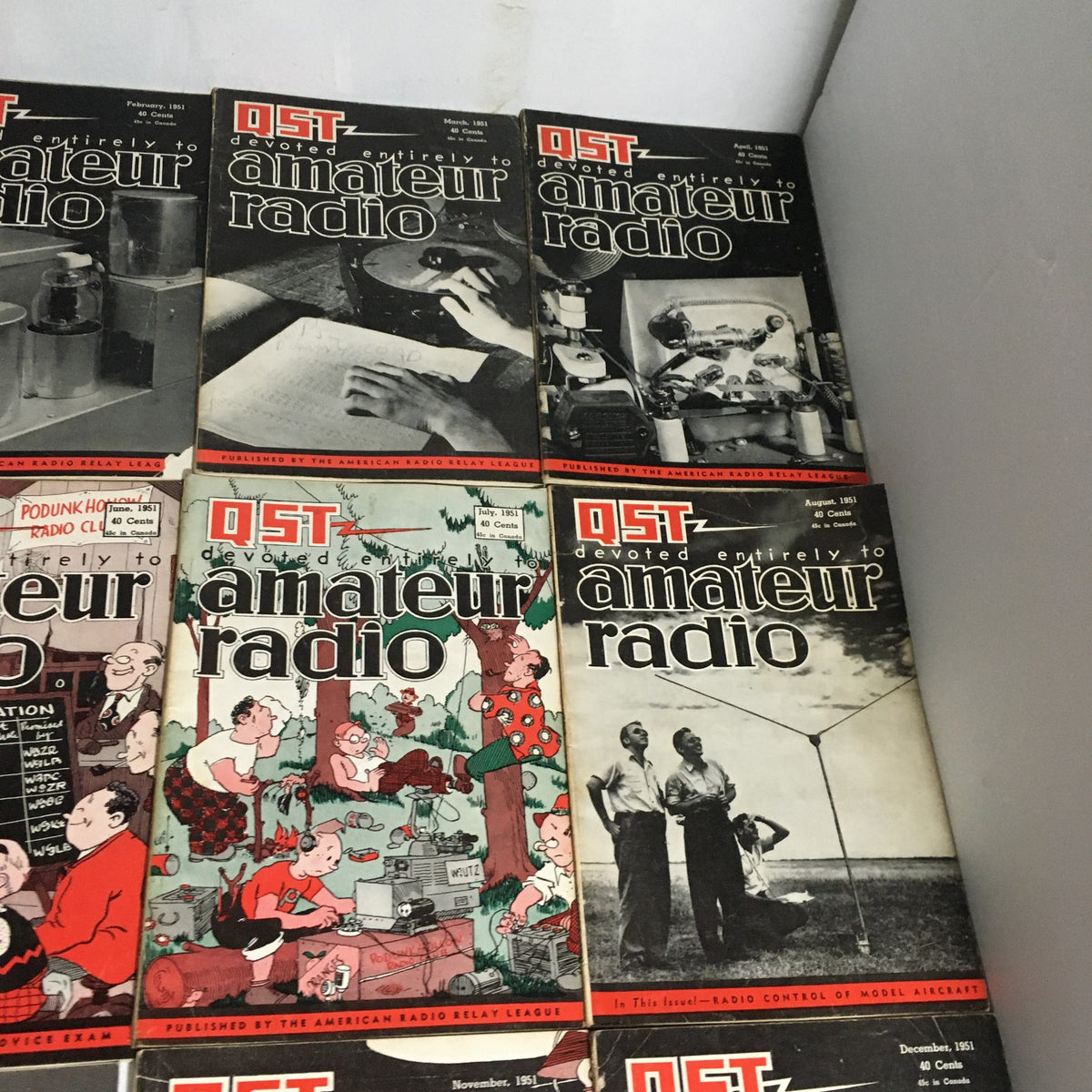 Lot of 12 Complete January to December 1951 QST Amateur Radio magazines displaying covers from February to August 1951 with engaging themes in amateur radio.