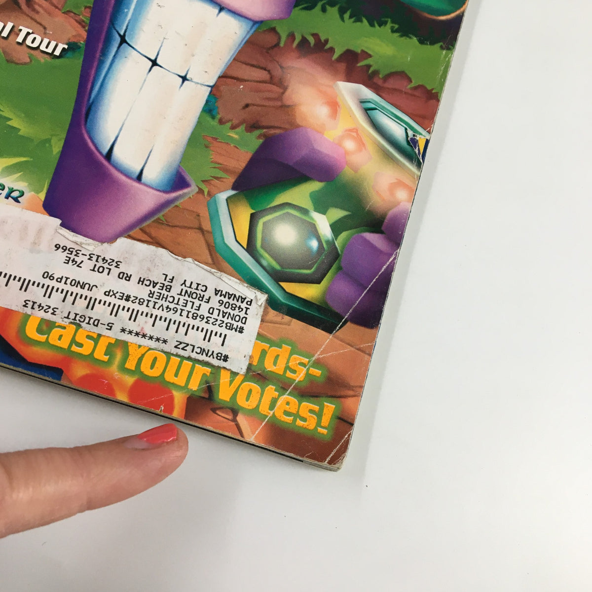 Close-up of the cover of Nintendo Power Magazine Vol. 118 highlighting the character from 'Tonic Trouble' along with a visible label and some signs of wear, emphasizing its vintage condition.