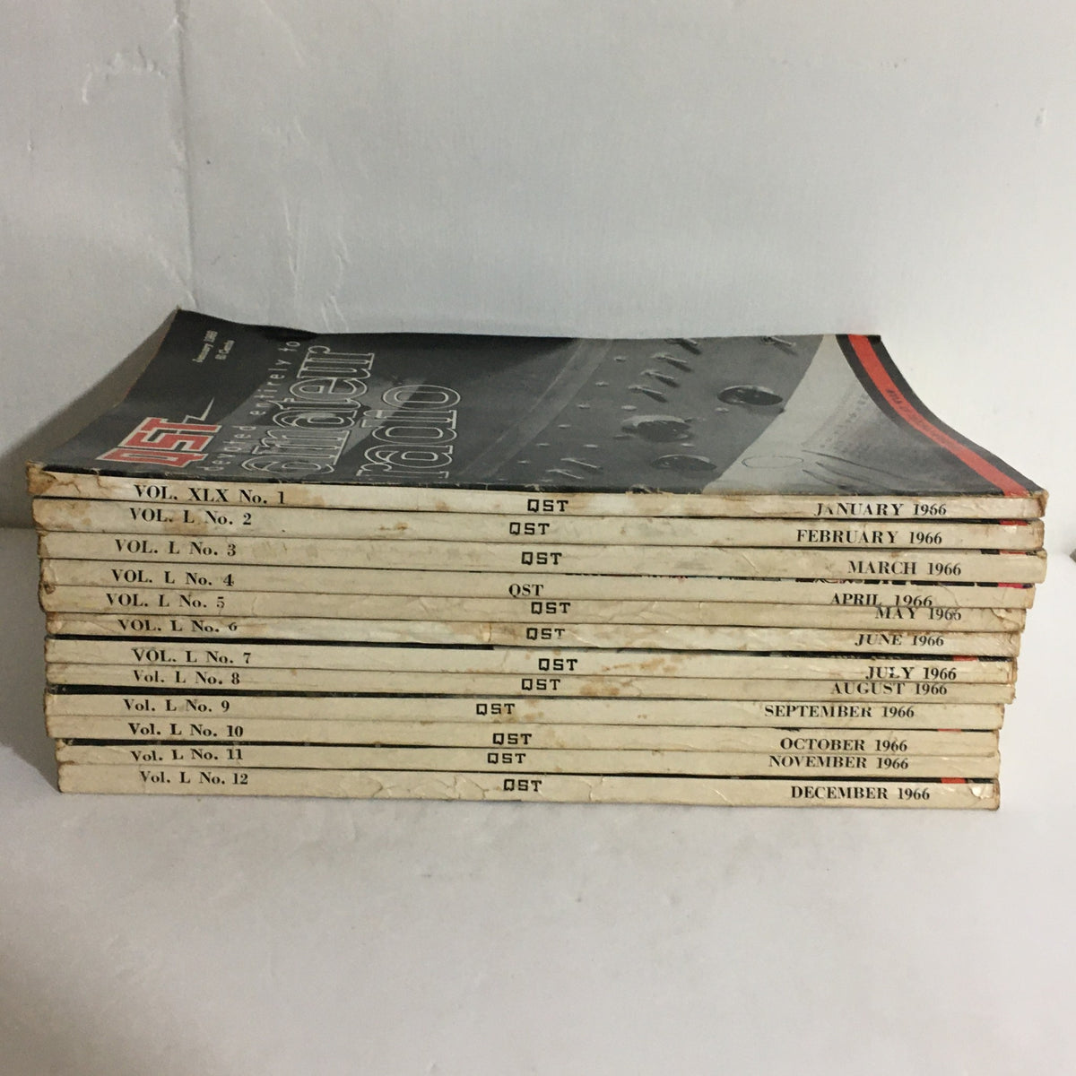 Lot of 12 Complete January to December 1966 QST Amateur Radio Volumes stacked and showing the chronological order of issues.