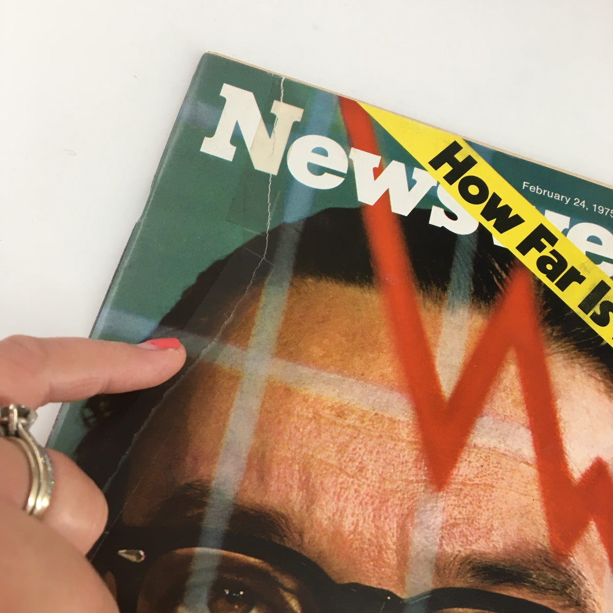 Close-up of the Newsweek Magazine February 24, 1975 cover showcasing a cracked corner and a pointer highlighting Alan Greenspan, the featured economic adviser.