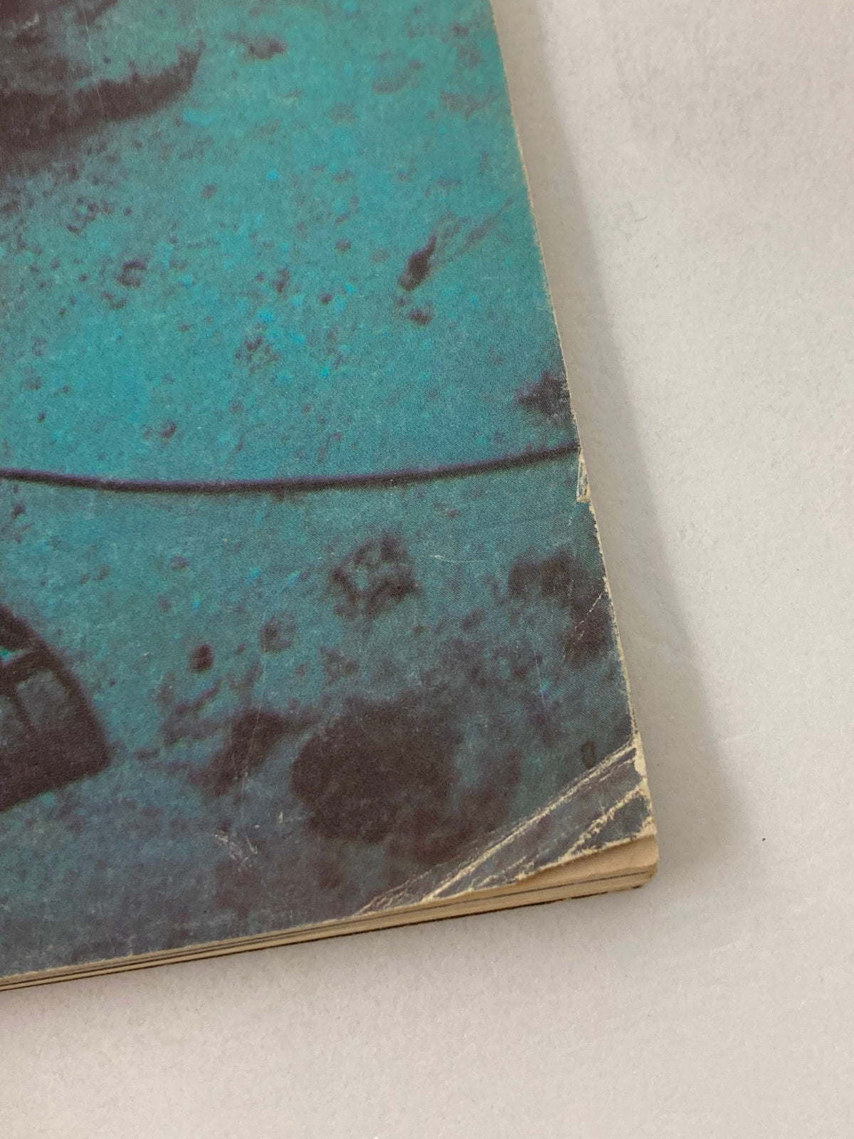 Close-up of the corner of the March 1977 issue of American Cinematographer Magazine featuring Peter Benchley's 'The Deep,' showcasing the vintage magazine's worn edges and underwater-themed cover design.