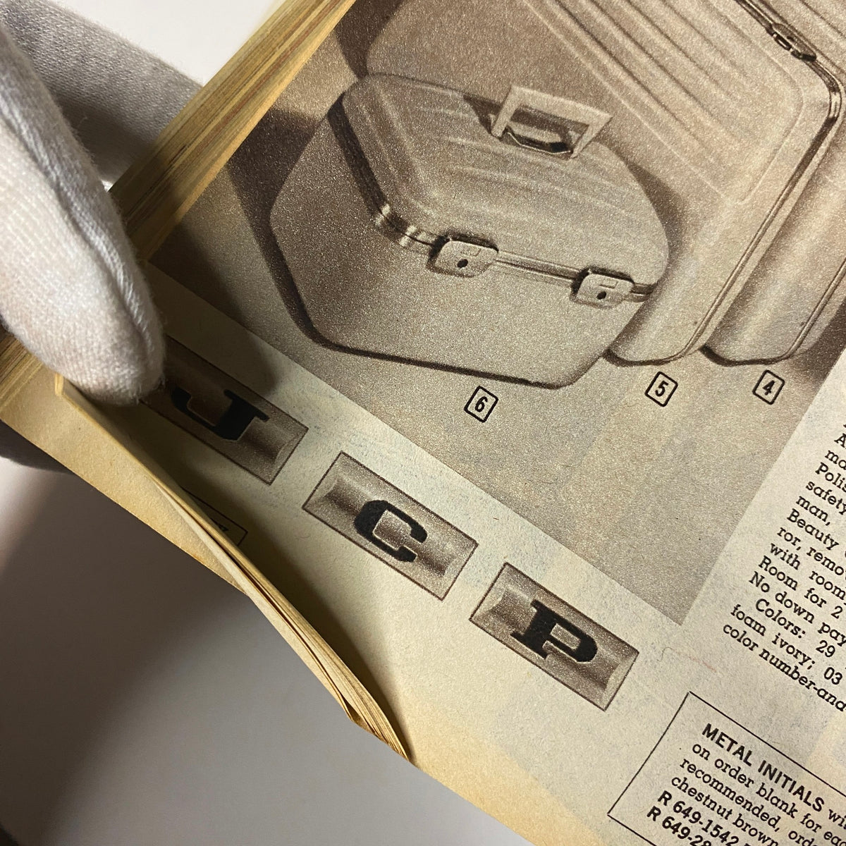 Close-up image from the 1964 JC Penneys Fall and Winter Store Catalog showing metal initials 'JCP' on luggage, emphasizing vintage branding design.
