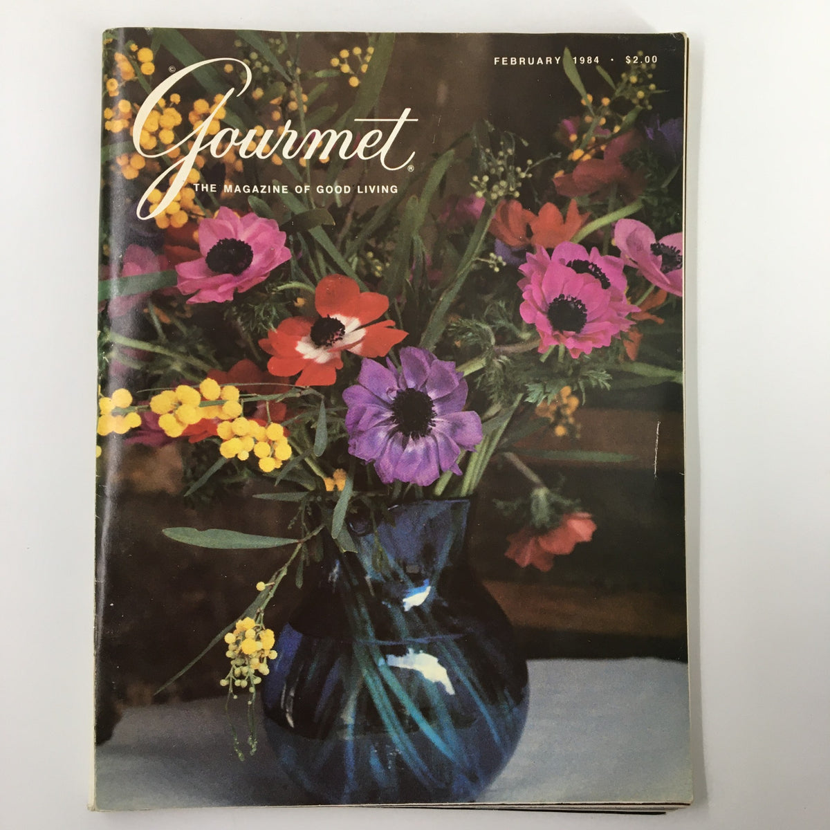 Cover of VTG Gourmet Magazine February 1984, featuring Saint Bridget's Anemones and Acacia in a floral arrangement, capturing the essence of gourmet cooking.