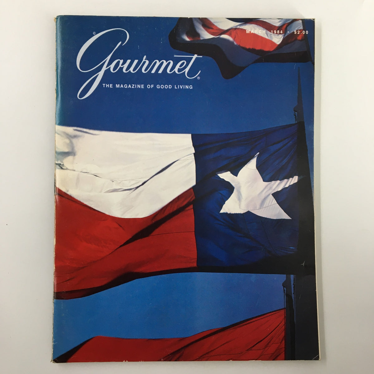 Cover of the VTG Gourmet Magazine March 1984 edition titled 'The Flag - The Lone Star', showcasing a vibrant blue background with the Texas flag prominently displayed.