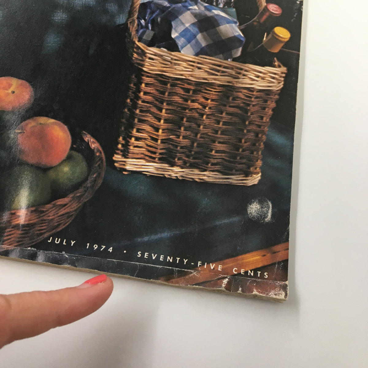 Close-up view of the picnic basket on the cover of VTG Gourmet Magazine July 1974 showing fresh fruits and a checkered cloth.
