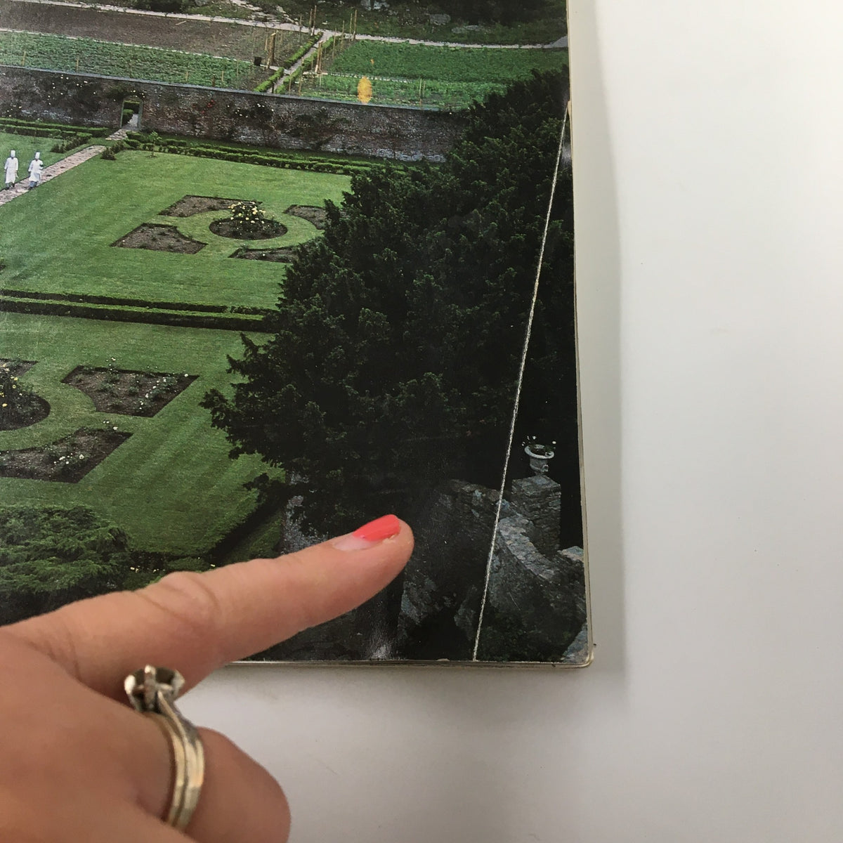 Close-up of the VTG Gourmet Magazine June 1983 cover, focusing on the garden area with a finger pointing to a decorative element, emphasizing the magazine's vintage charm.