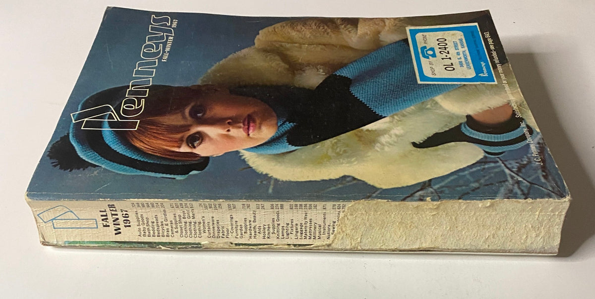 Side view of the 1967 JC Penneys Fall and Winter Store Catalog showing its spine and the model on the cover dressed in winter attire, emphasizing vintage style and design.