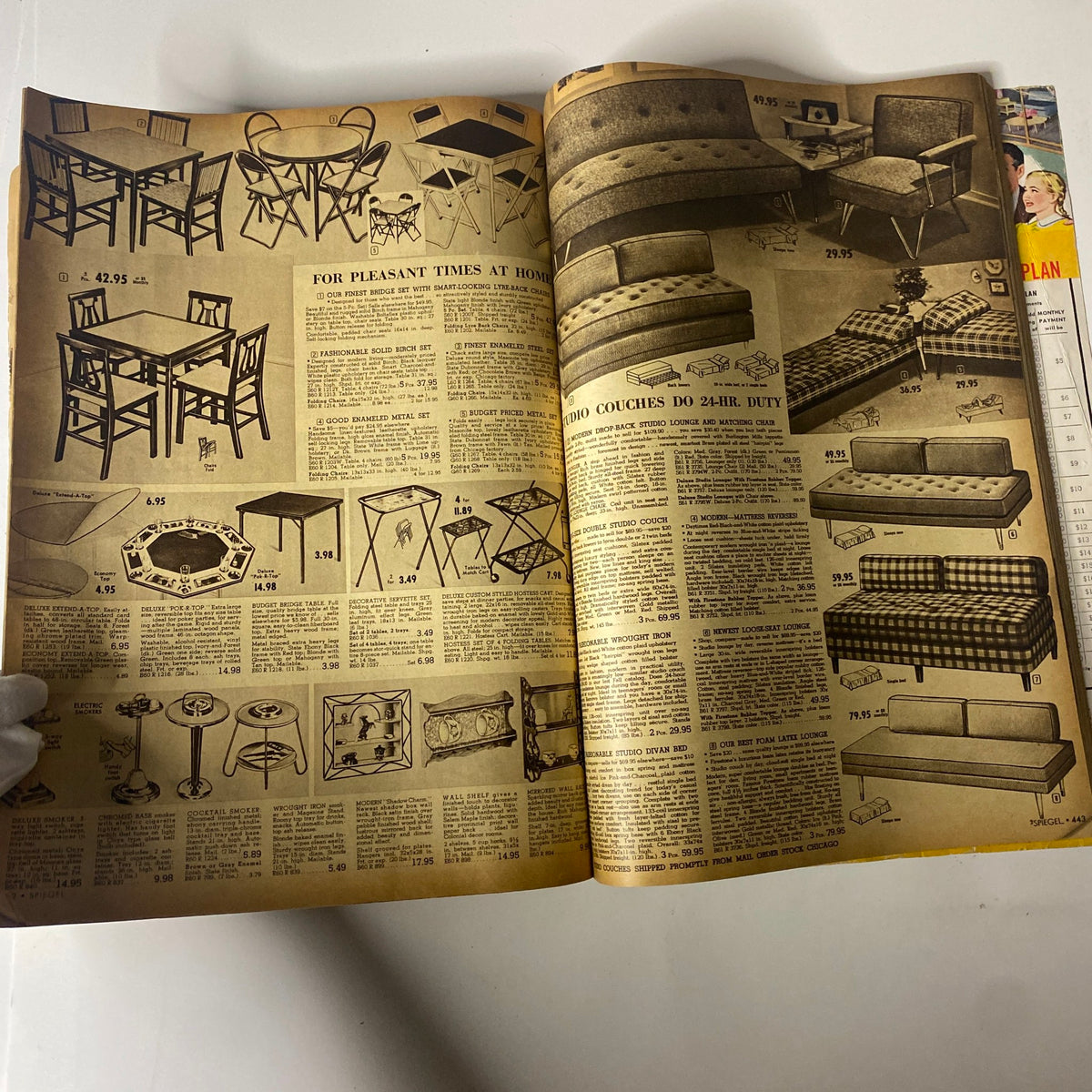 Interior page of the 1955 Spiegel Fall and Winter Catalog featuring various furniture selections including tables and sofas, illustrating classic mid-century American furnishings.