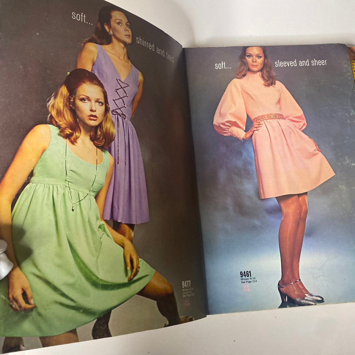 Inside spread of the 1968 November McCall's Holiday Wear Catalog displaying three stylish holiday dresses in pastel colors, highlighting designs that emphasize soft fabrics and elegant silhouettes.
