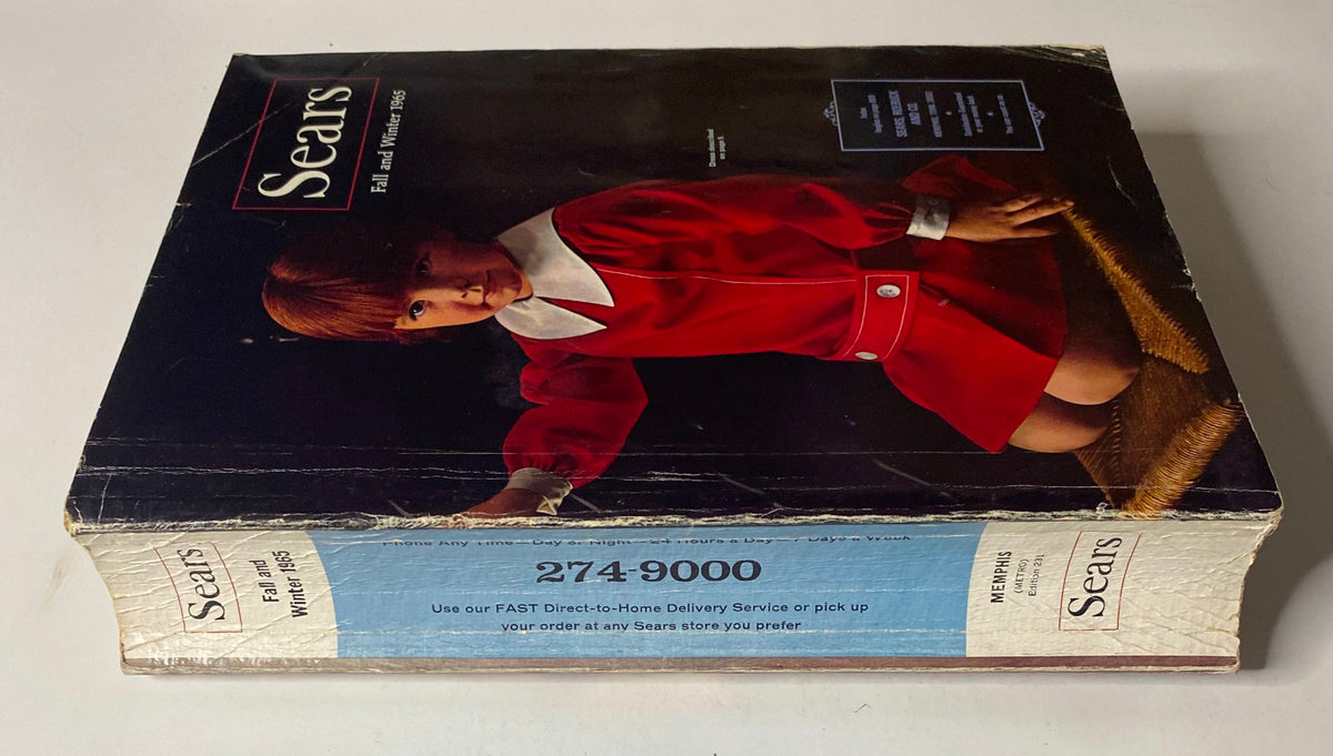Side view of the 1965 Sears Fall and Winter Catalog featuring the cover image of a young girl in a red dress. A glimpse into mid-century fashion and consumer culture.