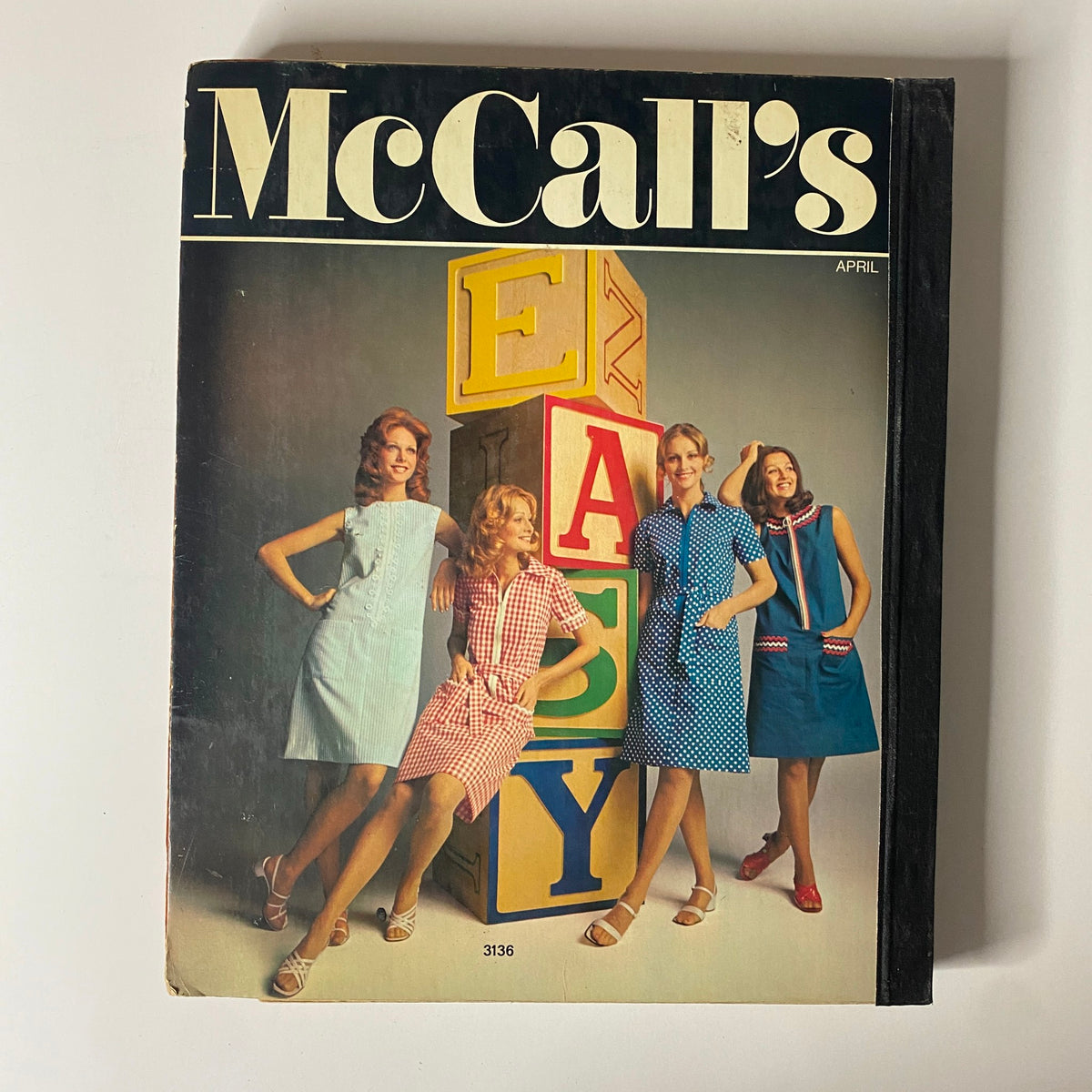 Cover of the 1972 April McCall's Catalog featuring vibrant fashion illustrations and models in stylish dresses, showcasing the theme 'EASY' with colorful stacked blocks, ideal for vintage fashion enthusiasts and sewing aficionados.