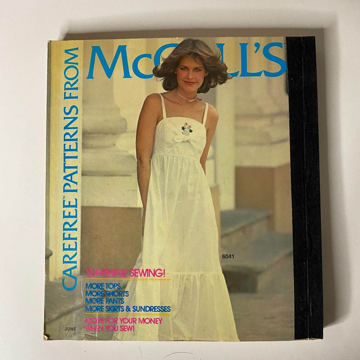1970s June Carefree Patterns McCall's cover image featuring a model in a long white sundress, promoting the care-free sewing style and summer patterns of the 1970s.