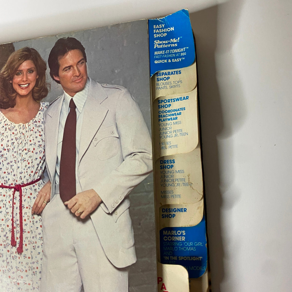 Close-up of the 1977 July Carefree Patterns from McCall's Summer Catalog showcasing a fashion page with a couple dressed in vintage styles.