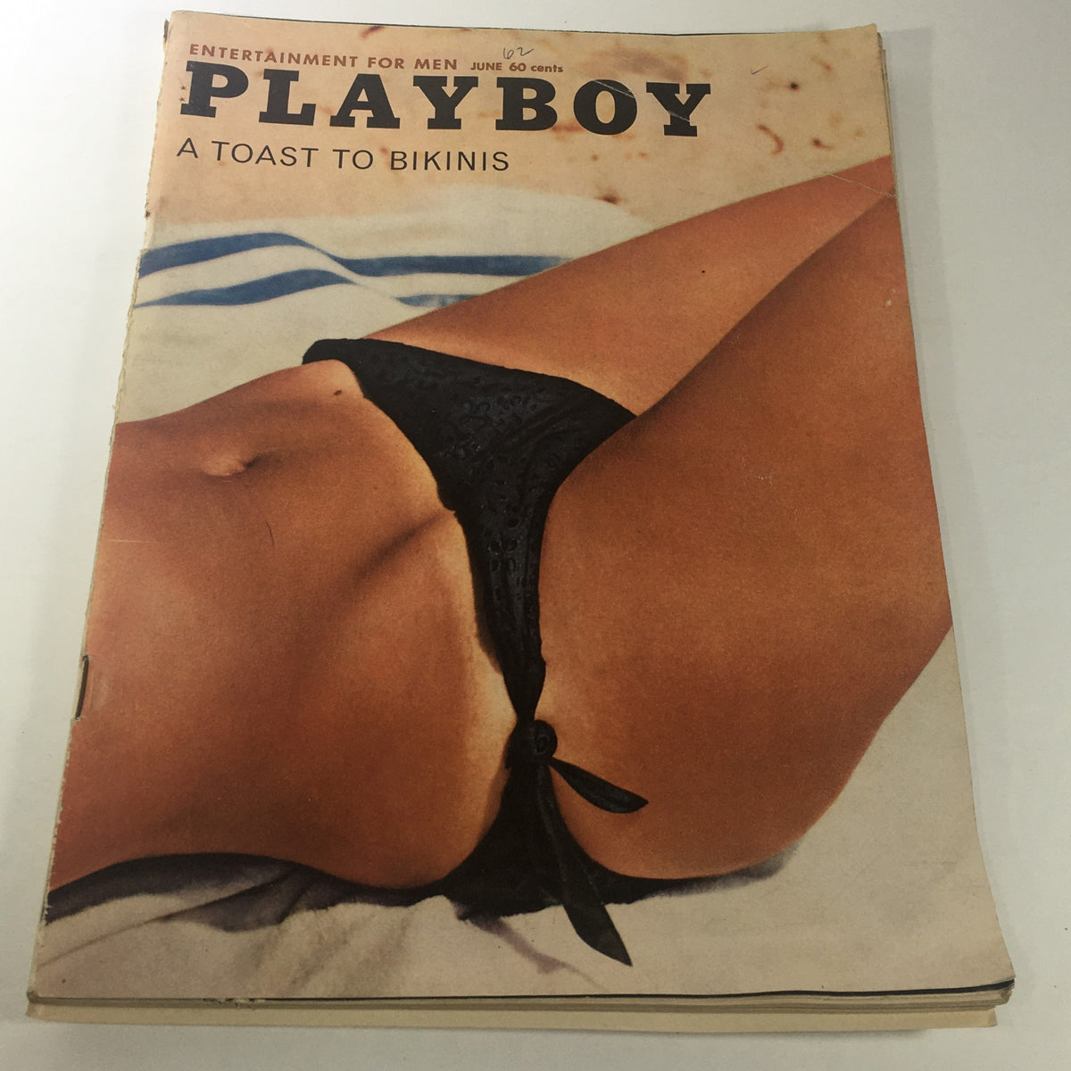 VTG Playboy Magazine: June 1962 cover featuring a close-up of a bikini-clad model, with the title "A Toast To Bikinis." This iconic vintage magazine captures the essence of early 1960s fashion.