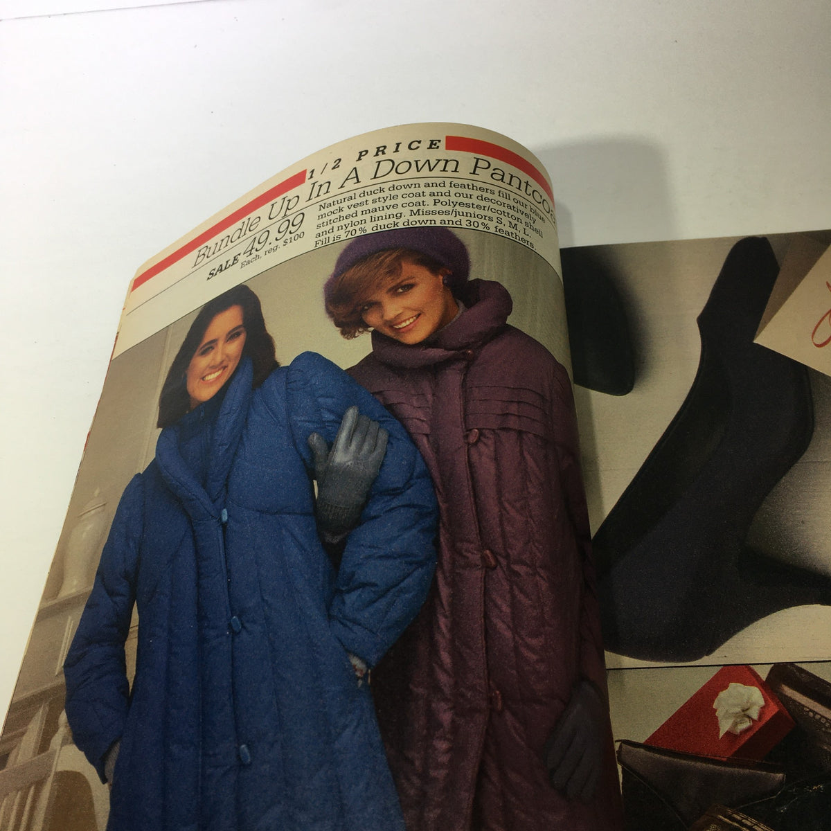 VTG Montgomery Ward Store Catalog: December 1984 showcasing two models wearing stylish down puffer coats in blue and purple, highlighting winter fashion trends from the 1980s.