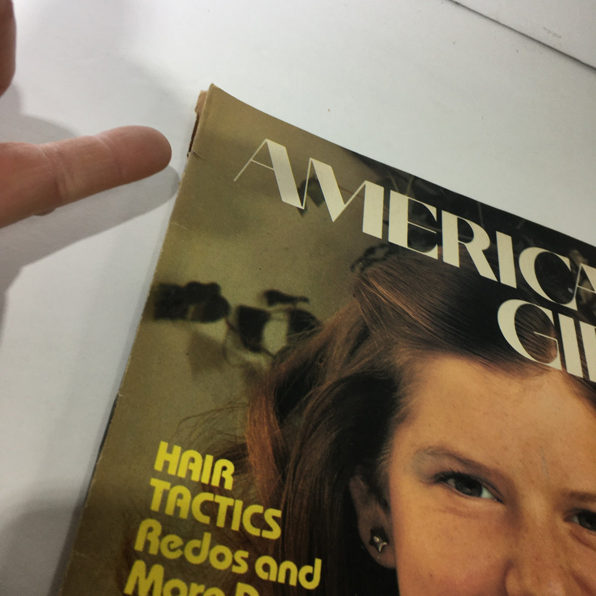 Close-up of the VTG American Girl Magazine March 1977 cover highlighting the edges and authenticity, featuring the title 'This Village Blacksmith Is A Woman'.