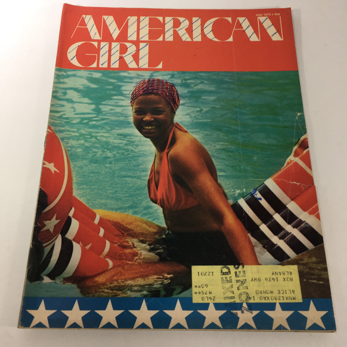 Cover of VTG American Girl Magazine: July 1975 featuring a woman in a swimsuit at the poolside, embodying the style and trends of the 1970s.