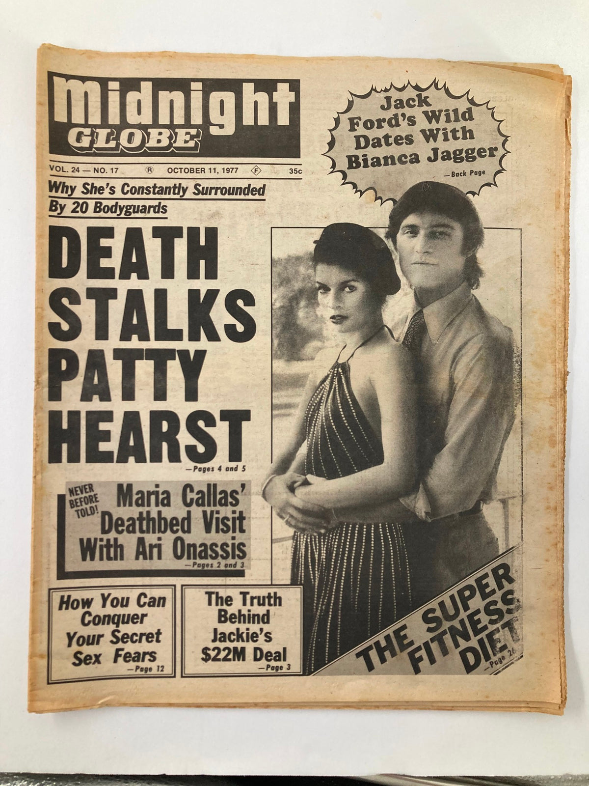 Midnight Globe Tabloid October 11 1977 Vol 24 #17 featuring Jack Ford and Bianca Jagger on the cover. The magazine discusses Patty Hearst, Maria Callas, secret fears, and more. A vintage publication characterized by wear and yellowing.