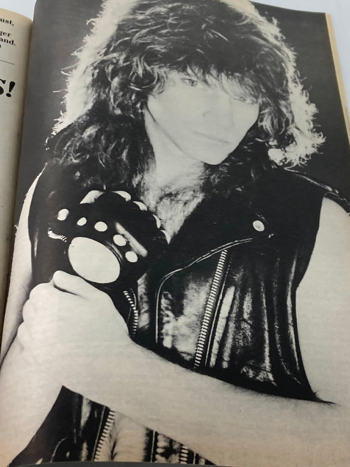 Close-up black and white image of a male musician with long hair holding a studded leather accessory, featured in Stars & Rockers Magazine 1984 Vol 1 #1.