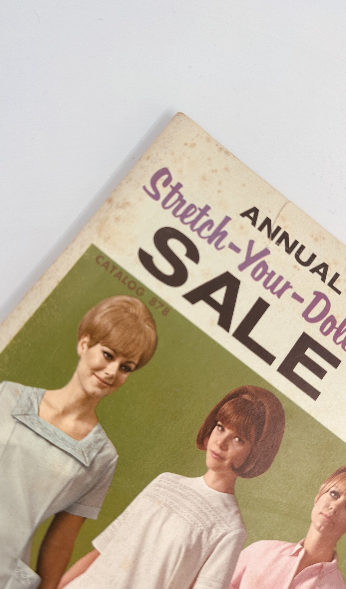 Close-up view of the 1967 James G. Fast Catalog featuring the Stretch Your Dollar Sale, emphasizing stylish nurse uniforms and dresses.