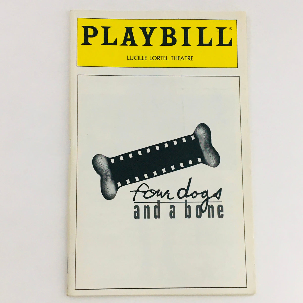 1994 Playbill for Four Dogs and a Bone by John Patrick Shanley at Lucille Lortel Theatre, showcasing a minimalist black and white design with a bone motif.