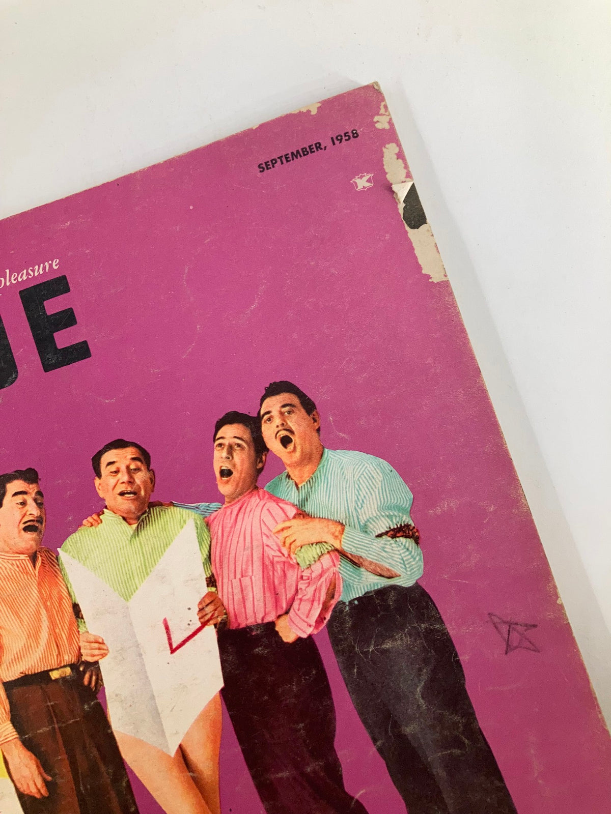 Close-up of the cover of VTG The Dude Magazine September 1958, showcasing the title and the enthusiastic expressions of four men in vibrant attire.