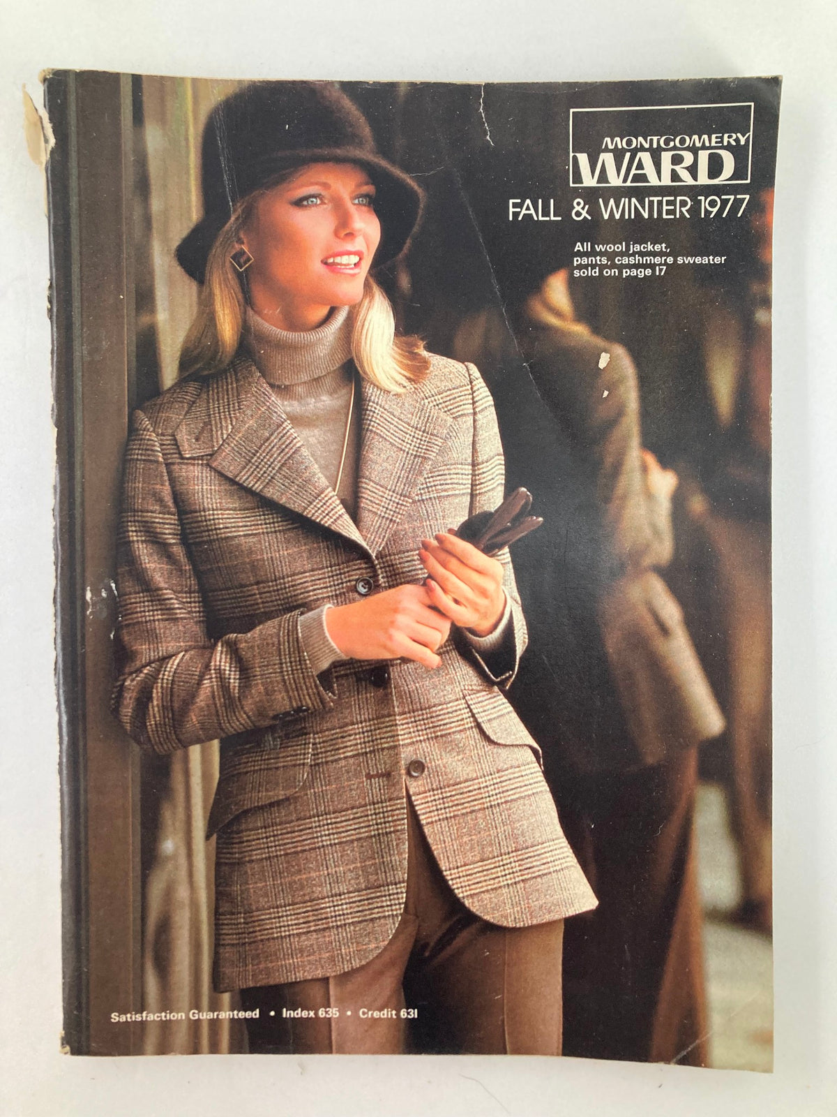 Cover image of the 1977 Fall & Winter Montgomery Ward & Co. Catalog featuring a fashionable woman in a plaid wool jacket and hat, showcasing classic fall fashion styles from the late 1970s.