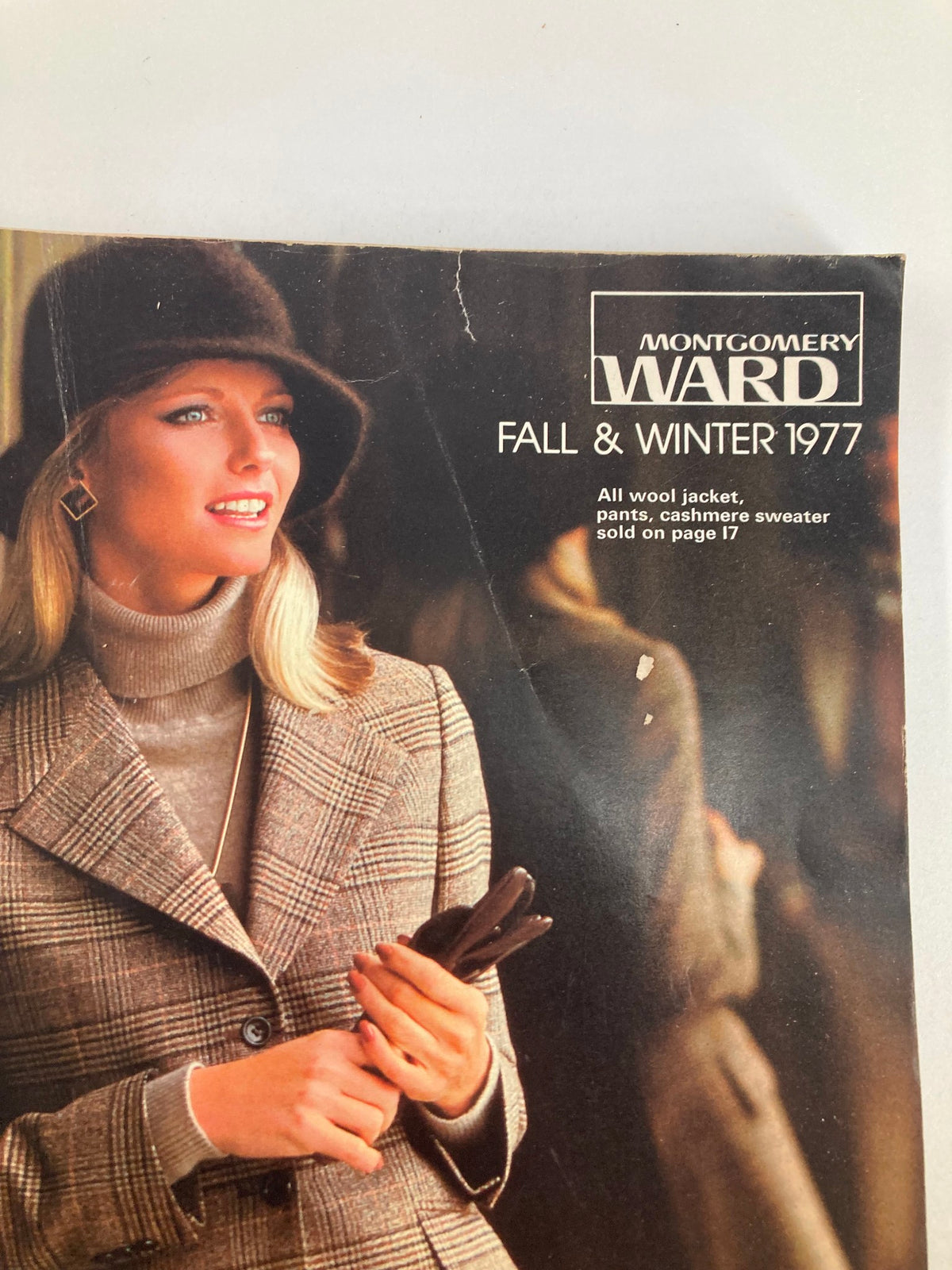 Front cover of the 1977 Fall & Winter Montgomery Ward & Co. Catalog, highlighting a woman in a fashionable hat and plaid jacket, representing the fashion trends of the 1970s.