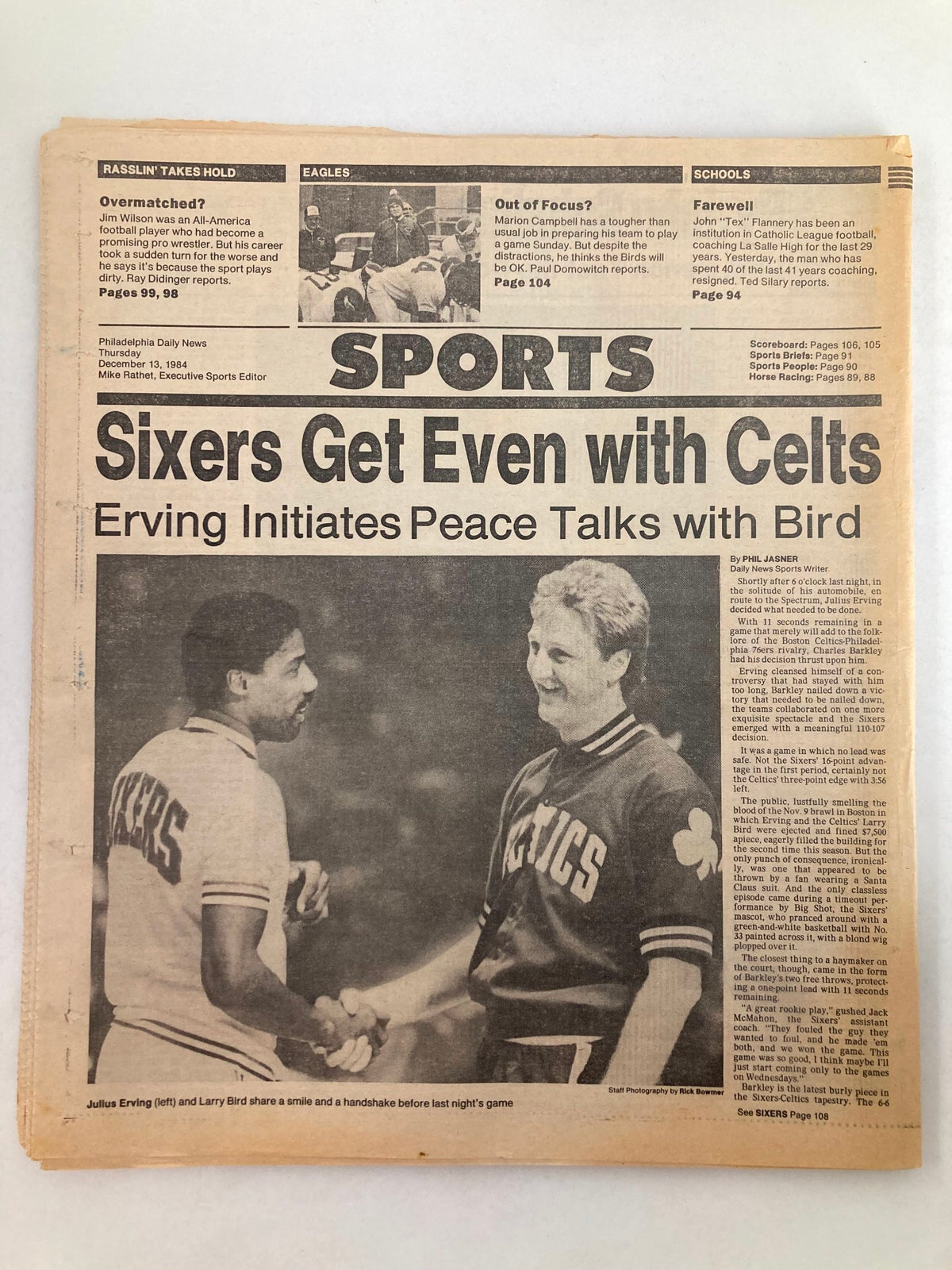 Sports section of the Philadelphia Daily News Tabloid from December 13, 1984, featuring an article on the Philadelphia 76ers and Boston Celtics game, illustrating players Julius Erving and Larry Bird shaking hands.