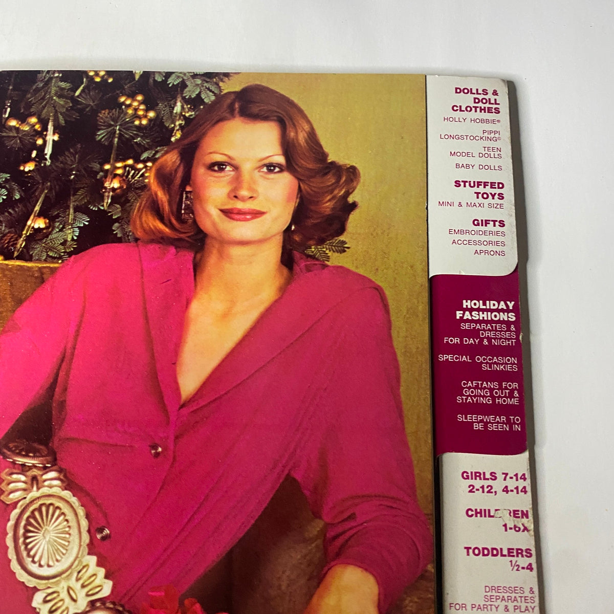 1973 Simplicity Holiday Gift Catalog cover featuring a stylish woman in a pink outfit, embodying festive elegance, surrounded by holiday decorations.